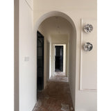 Two marble discs on a wall beside an arched hallway