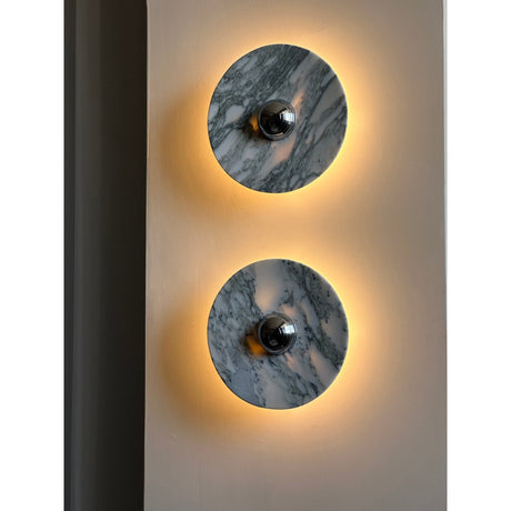 Two lit discs showing the gray veining of the marble