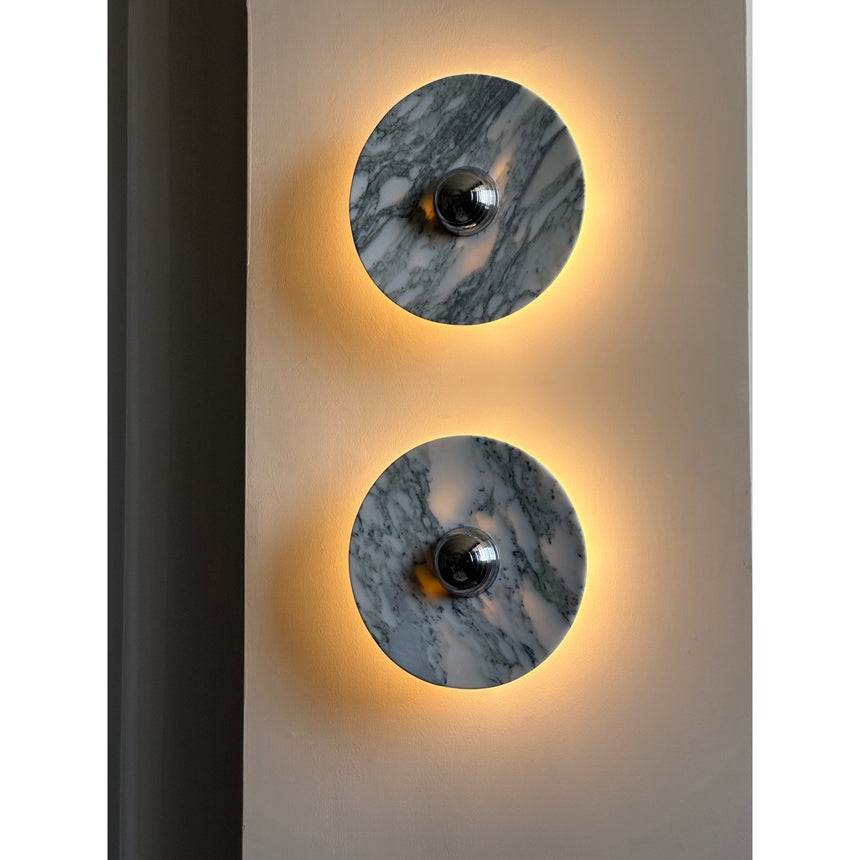 Two lit discs showing the gray veining of the marble