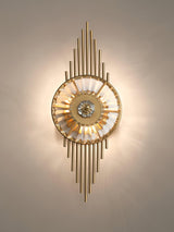 The sconce lit warm on a beige wall, light radiating from the crystal wheel