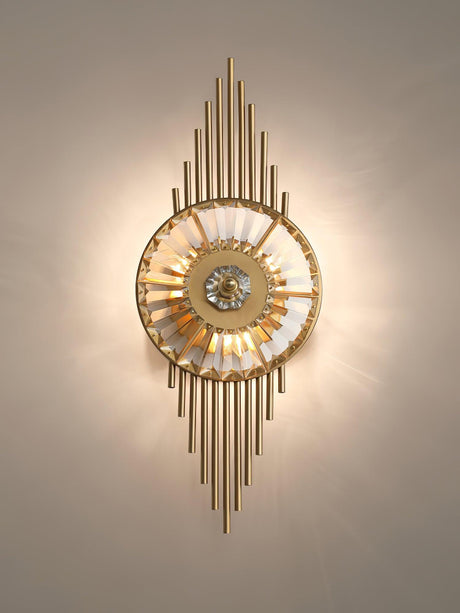 The sconce lit warm on a beige wall, light radiating from the crystal wheel