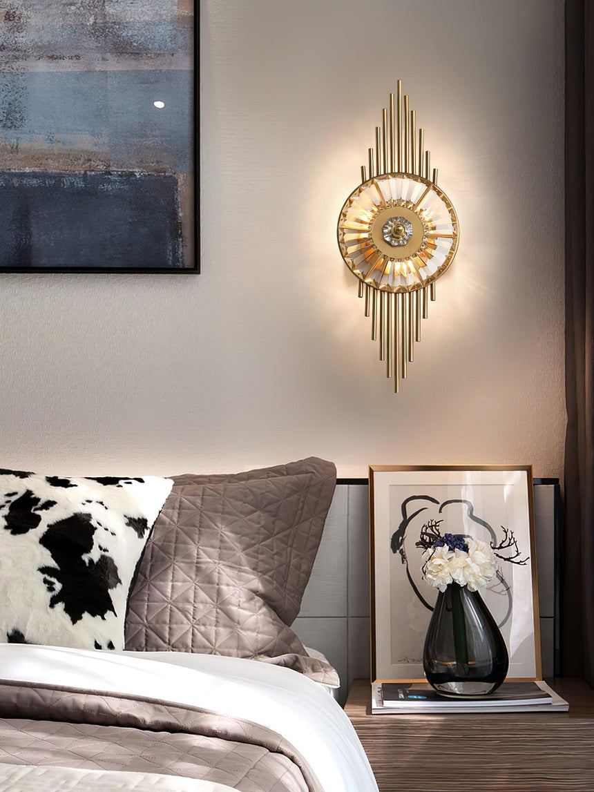 The sconce above a nightstand with a framed print and a vase beside a bed