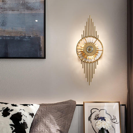 The sconce lit beside an abstract painting above a bed with cushions