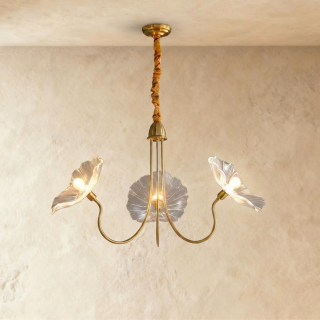 Brass arms carrying three clear blown glass poppy shades, each lit at its center