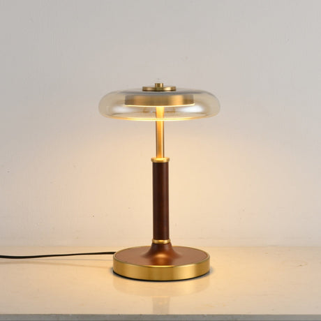 Close view of the round brass foot under the walnut column