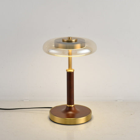 Close view of the lit glass disc above the brass collar and stem