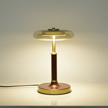 Clear glass disc lamp lit, the light spreading through the glass