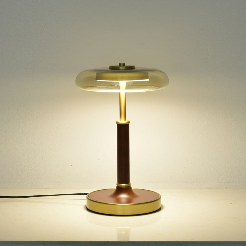 Clear glass disc lamp lit, the light spreading through the glass