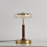 Clear glass disc lamp unlit against a pale gray ground