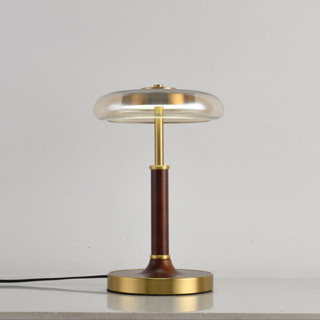 Clear glass disc lamp unlit against a pale gray ground