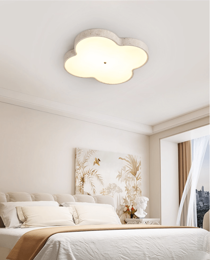 Travertine cloud ceiling lamp lit above a bed with dried grasses and sheer curtains