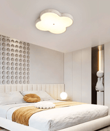 Cloud ceiling lamp lit in a bedroom with a slatted wall panel and a tan throw