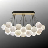 The raft of lit globes with the canopy bar in black and brass above it