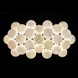 The full raft of lit alabaster globes on a dark ground, two layers deep