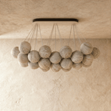 The globes unlit, pale stone spheres hung at two heights from the canopy