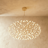 A flattened cloud of gold wire lattice studded with dozens of small white globes