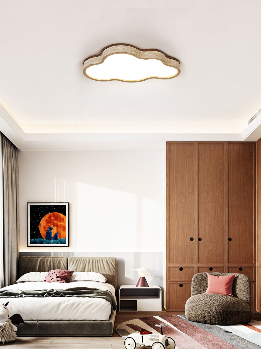 Travertine cloud ceiling light lit above a bed with cushions and a wooden wardrobe