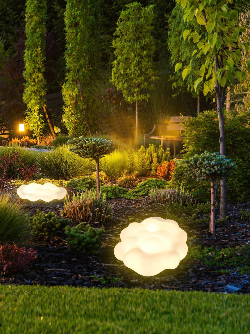 Two lit along a border beside a walk with tall cypress trees behind