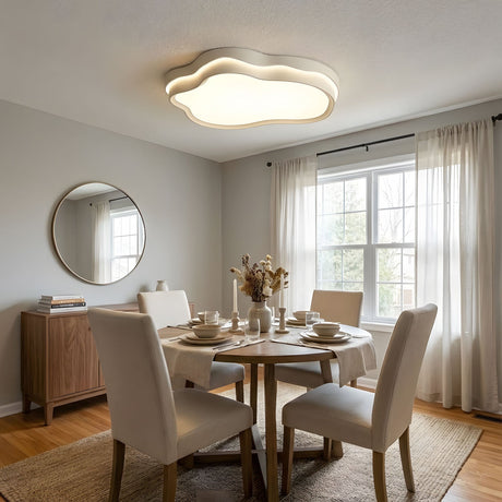 Layered cloud ceiling fixture lit above a dining table with upholstered chairs and a window behind
