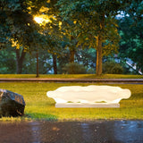 The cloud lit on wet grass beside paving reflecting the light