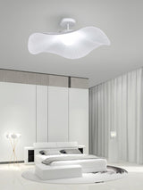Fabric wing ceiling light in a white bedroom with a low platform bed and a floor lamp