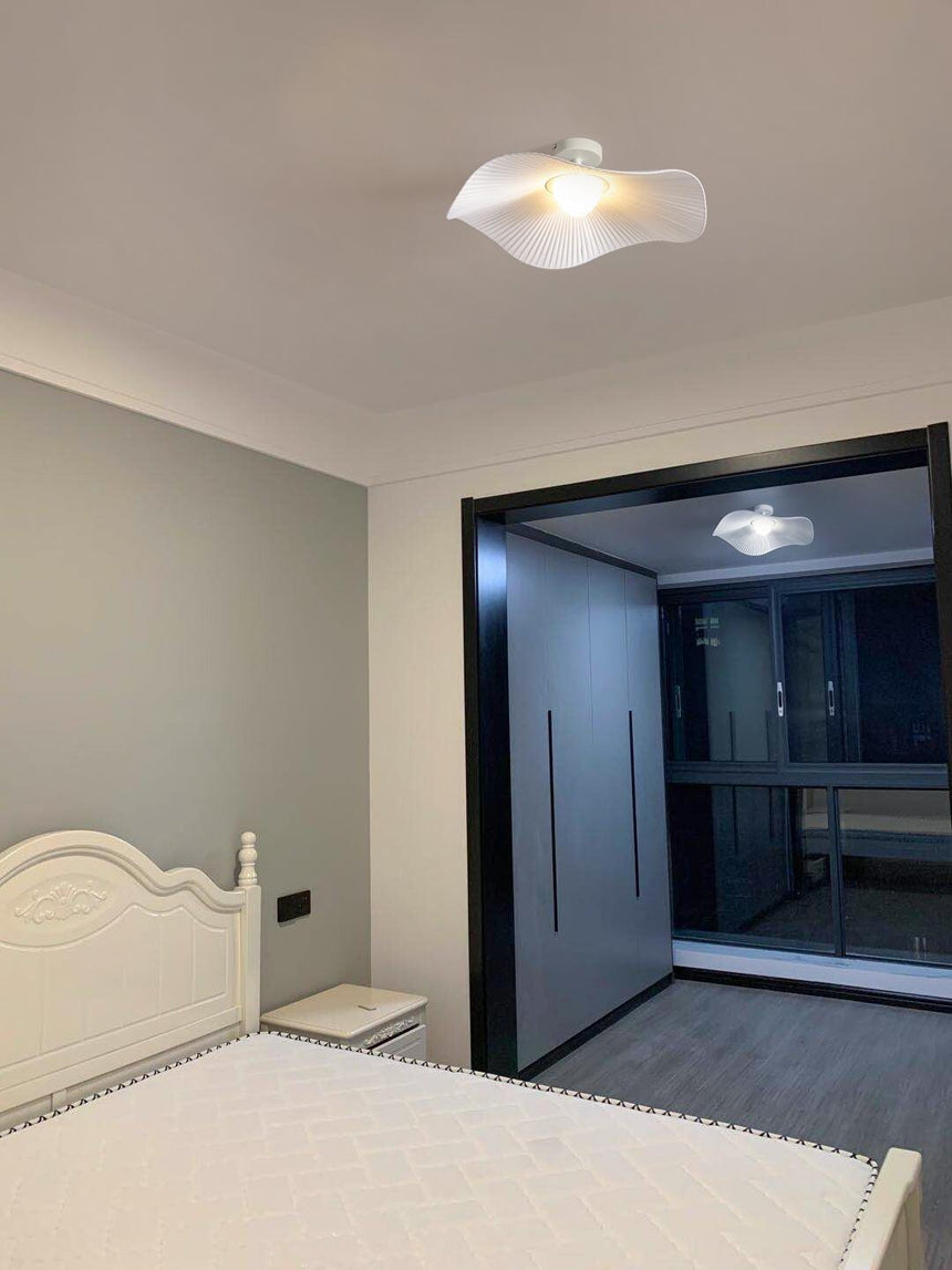 White fabric ceiling fixture in a classic bedroom with a carved bed and a dark doorway
