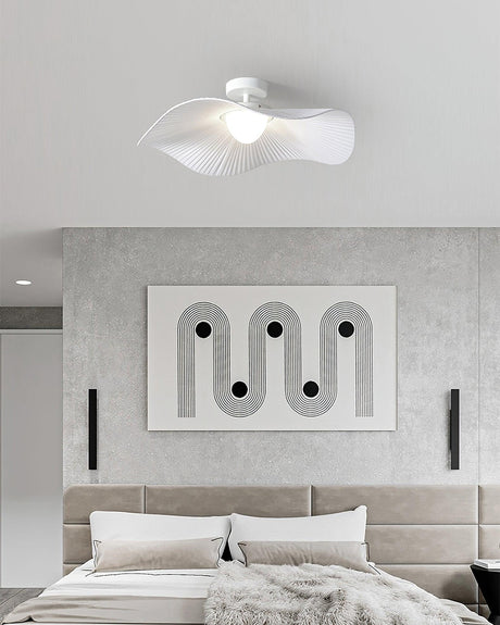 White fabric ceiling fixture over a bed with an upholstered headboard and a framed panel
