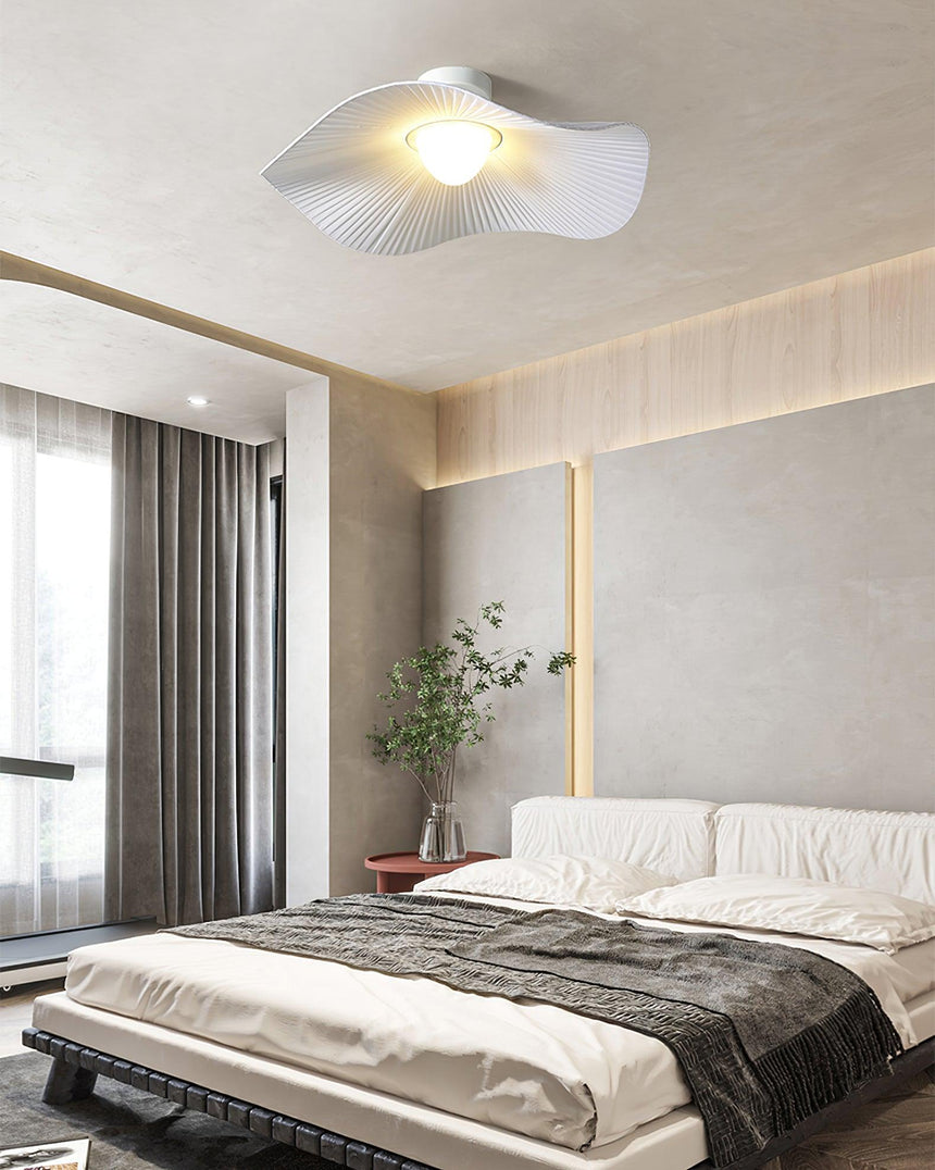 Fabric wing ceiling light in a warm bedroom with a wood slat wall and dark bedding