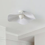 Unlit fabric wing ceiling light mounted near the corner of a plain white ceiling