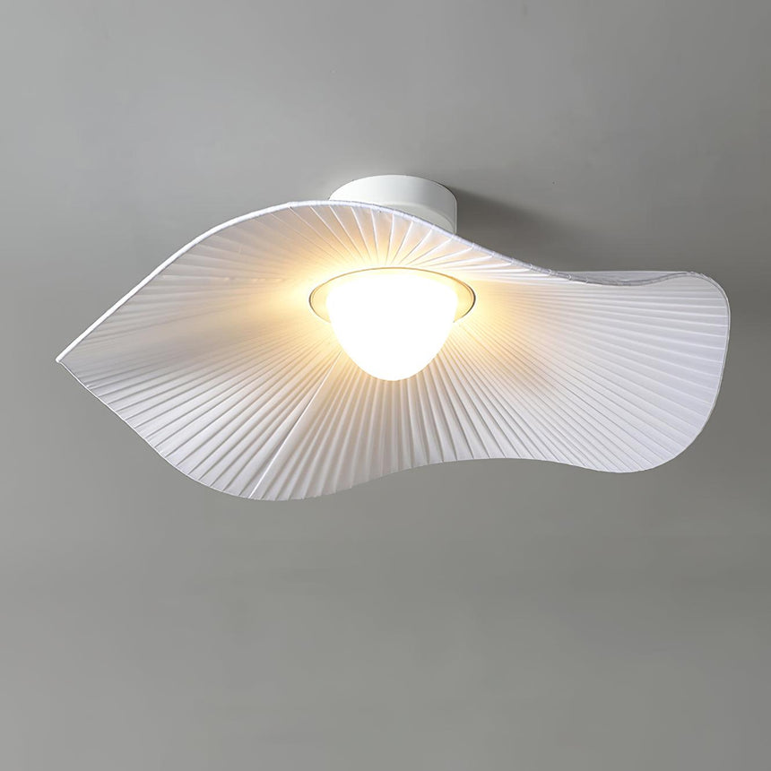 Fabric wing ceiling light lit warm, seen from the side against a gray wall