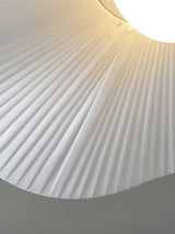 Close view of the pleated edge of the fabric shade where the wing lifts