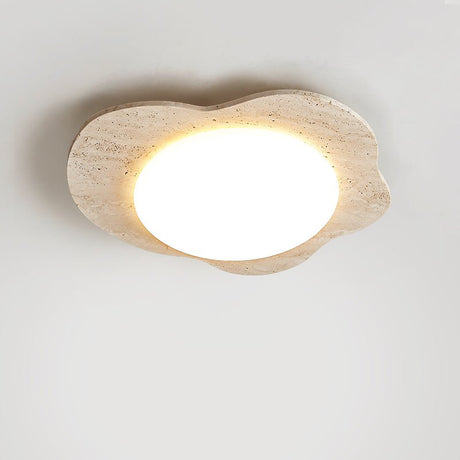 Lit travertine cloud ceiling light shown close up with the porous stone visible