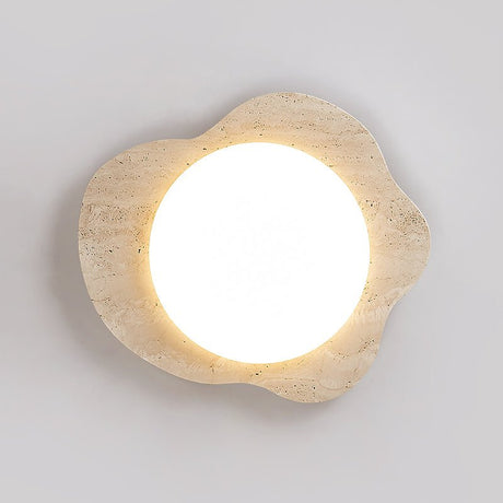 Round white diffuser glowing inside the travertine cloud frame, seen straight on