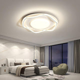 Cloud shaped ceiling lamp lit above a bed in a bedroom with a window wall at night