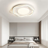 Cloud outline ceiling lamp lit over a bed with bedside tables and a tall headboard