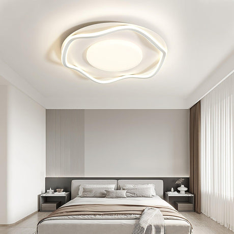 Cloud outline ceiling lamp lit over a bed with bedside tables and a tall headboard