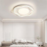 Cloud shaped ceiling lamp lit in a bedroom with a low bed and a framed print