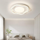 Cloud outline ceiling lamp above a bed with a tall plant and sheer curtains