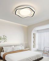 Cloud shaped ceiling lamp in black and white above a bed near an arched doorway