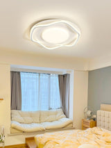 Cloud outline ceiling lamp above a daybed by a window with yellow bedding
