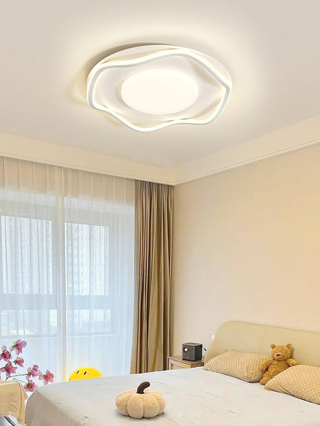 Cloud shaped ceiling lamp lit in a child bedroom with a soft toy on the bed