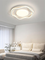 Cloud outline ceiling lamp lit over a bed with white linen and a vase of branches
