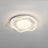 White cloud shaped ceiling lamp lit at an angle against a plain pale wall