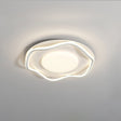 White cloud shaped ceiling lamp lit at an angle against a plain pale wall