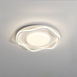 White cloud shaped ceiling lamp lit at an angle against a plain pale wall