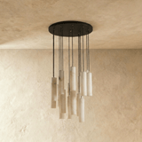 A large cluster of alabaster cylinders unlit, each one on its own black cord
