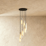 A long drop of lit alabaster cylinders spread down a plaster wall