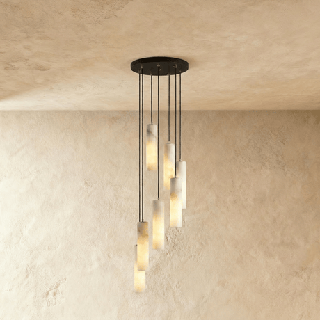 A long drop of lit alabaster cylinders spread down a plaster wall