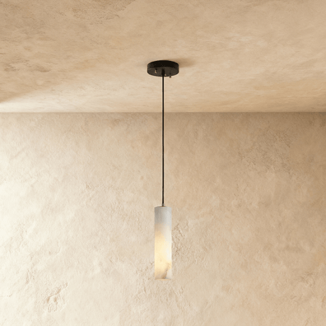One lit alabaster cylinder on a single black cord below a small plate