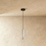 One unlit alabaster cylinder, the veining visible in the pale stone